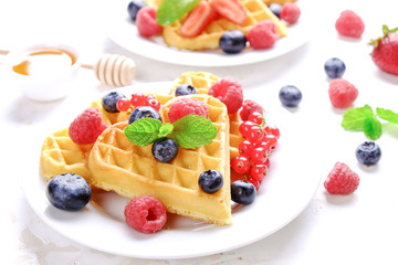 Heart shape belgium waffles with assorted berries mix, strawberry, blueberry, raspberry and red...