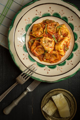 Traditional Italian Tortellini with Tomato Sauce, Mozzarella Cheese and Basil on Rustic Plate