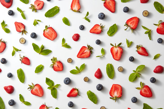 Fruit Pattern With Half Strawberries, Blueberries And Mint Leaves On A White Background, Top View