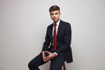 portrait of handsome and elegant businessman relaxing on wooden chair