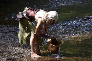 beautiful celtic woman draws water from the river