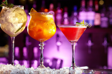 Three beautiful alcoholic cocktails with fruit.