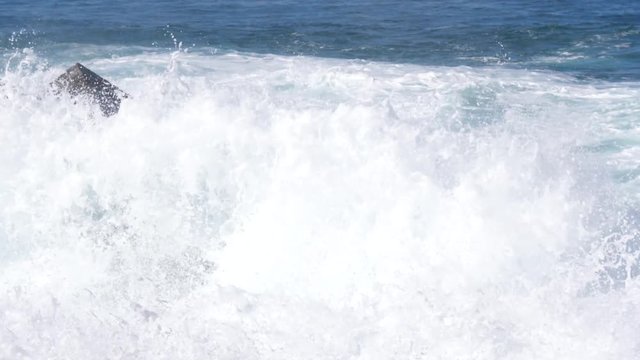 Scenic waves of Athlantic Ocean slow motion rush splashing to a stone shore of Tenerife