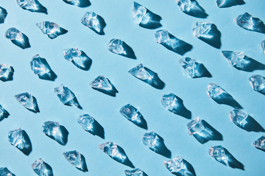 Pattern of pieces of clear glass ice on a blue background