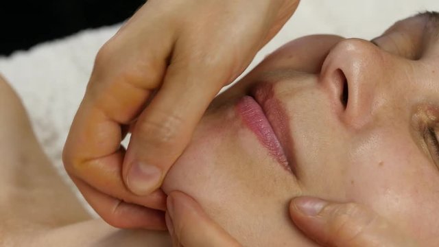plastic face massage in spa saton. woman enjoys the services of a professional massage therapist. 4K