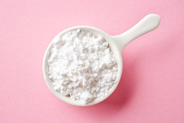 Powder sugar on pink background, from above