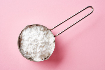 Powder sugar on pink background, from above