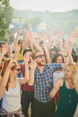 Group of people dancing and having a good time at the outdoor party/music festival - obrazy, fototapety, plakaty
