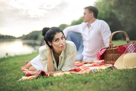 Lovely couple having a picnic next to the river