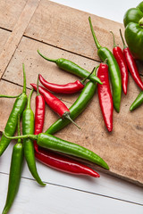 Chili colored peppers for cooking sauce on an old wooden board