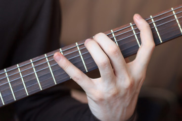 Man is playing guitar close up