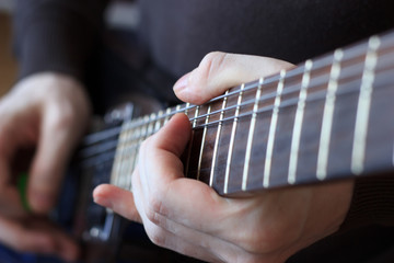 Fototapeta premium Man is playing guitar close up