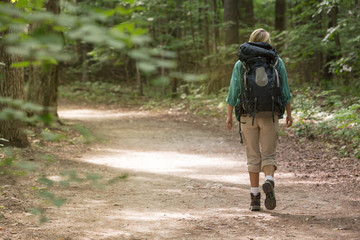 Woman Backpacker hiking along hiking trail
