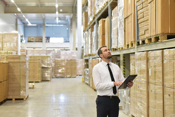Businessman in the transport sector controls a warehouse // Manager in einer Lagerhalle bei der...