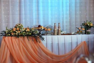 Festive table decoration for the newlyweds in the restaurant, bouquets and champagne