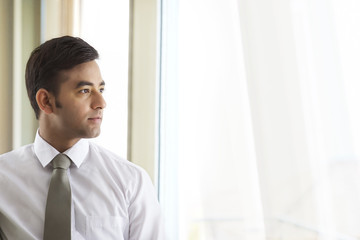 Fototapeta premium Portrait of confident businessman looking out of window