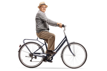 Fototapeta premium Senior riding a bike and looking at the camera