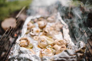 Brown champignon portobello mushrooms being cooked on char grill