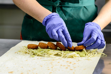 Process of preparing appetizing roll with falafel, sauce and pic