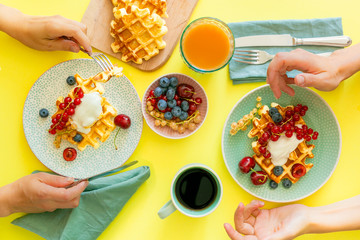 Breakfast with waffles, wipped cream, berries and granola