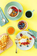 Breakfast with waffles, wipped cream, berries and granola