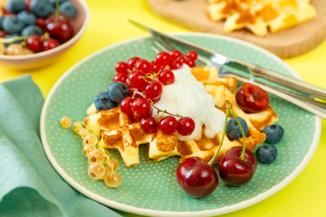 Breakfast with waffles, wipped cream, berries and granola