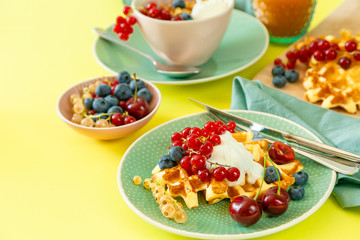 Breakfast with waffles, wipped cream, berries and granola