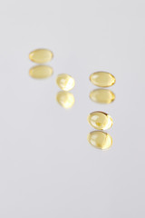 close-up shot of omega fish hat supplement capsules on reflective surface
