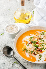 Trendy vegan food, Sweet Potato Detox Soup with coconut milk, dried tomatoes, peanuts and herbs, on grey stone table copy space
