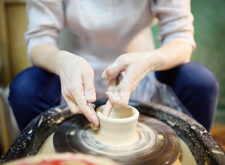 Fototapeta na wymiar Close-up photo of hands of woman making clay object