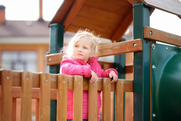 Cute little girl having fun on outdoor playground