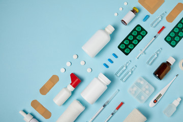 top view of various medical supplies composed in rows on blue tabletop