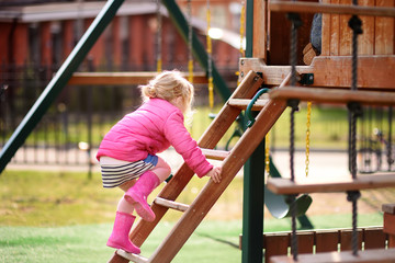 Cute little girl having fun on outdoor playground