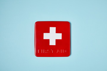 top view of red first aid kit box on blue surface