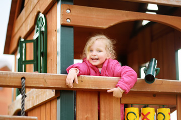 Cute little girl having fun on outdoor playground
