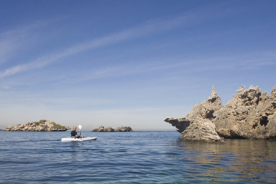 A Man Kayaking Around Rocky Islands In Shoalwater Western Australia.