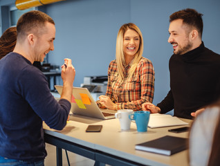 Creative people laughing at office meeting