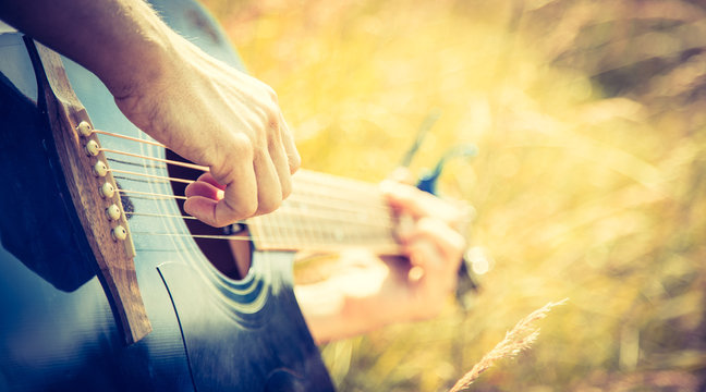Musizieren mit Gitarre in der Wiese, Gitarrenkorpus, Hals und H&auml;nde, Freiraum, Breitbild
