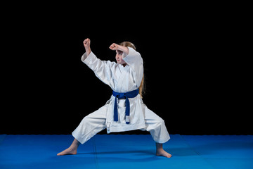 sweet little girl in martial arts practice like karate kid alone isolated on black background © FS-Stock