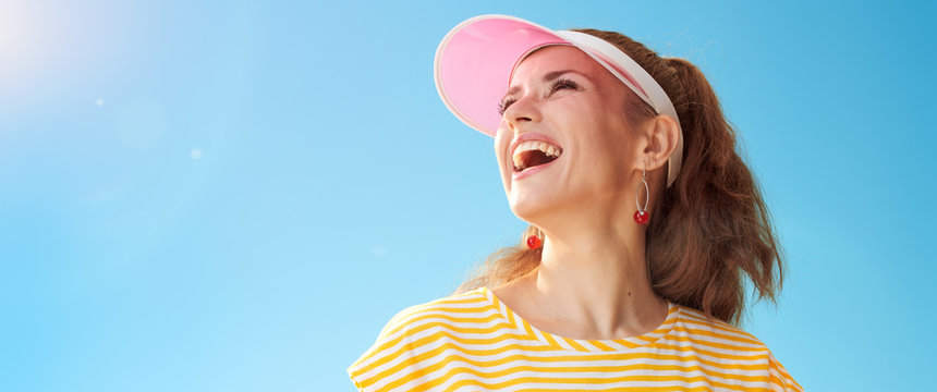 smiling active woman against blue sky looking into distance