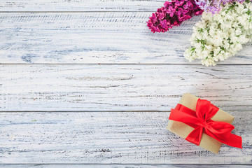 gift and flowers on a wooden background