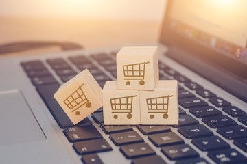 Buy online concept with trolley on wooden cubes on a keyboard of laptop