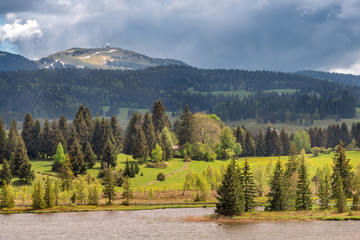 French landscape - Jura. View over the lake of Les Rousses in the Jura mountains (France) with the Mount La Dole (Switzerland) in the background. - obrazy, fototapety, plakaty