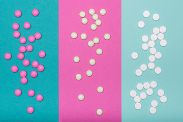 Assortment of various colourful pills isolated on pastel colored background. Medication and prescription pills flat lay background.