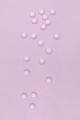 Pale pink pills on pastel colored pink background. Medication and prescription pills minimal background.