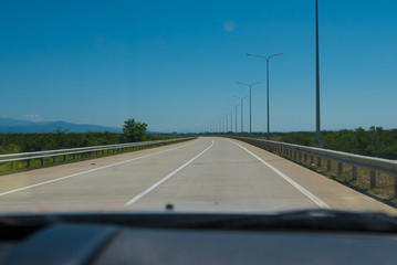 Road trip view from the car asphalt and blue sky