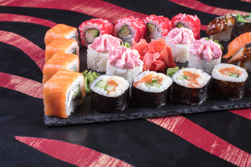 Суши и роллы и креветки. Японская еда и морепродукты в ресторане. Японская кухня. Горячие и холодные закуски из морепродуктов
