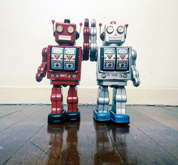 two vintage robot toy happy together on a wooden floor