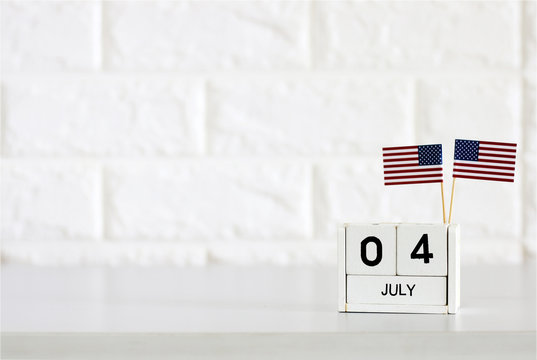 4th Of July Calendar And American Flag On The Table White Brick Wall Background Concept Happy Independence Day