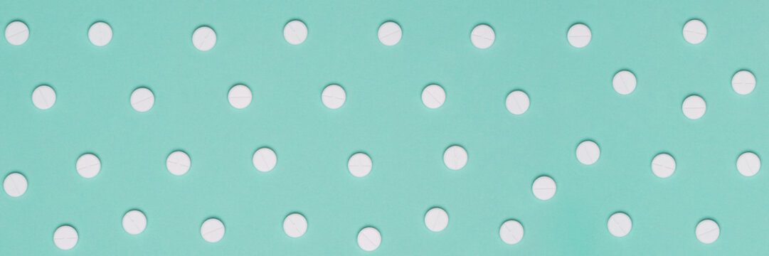 White pills on turquoise pastel colored background. Medication and prescription pills minimal web banner background.